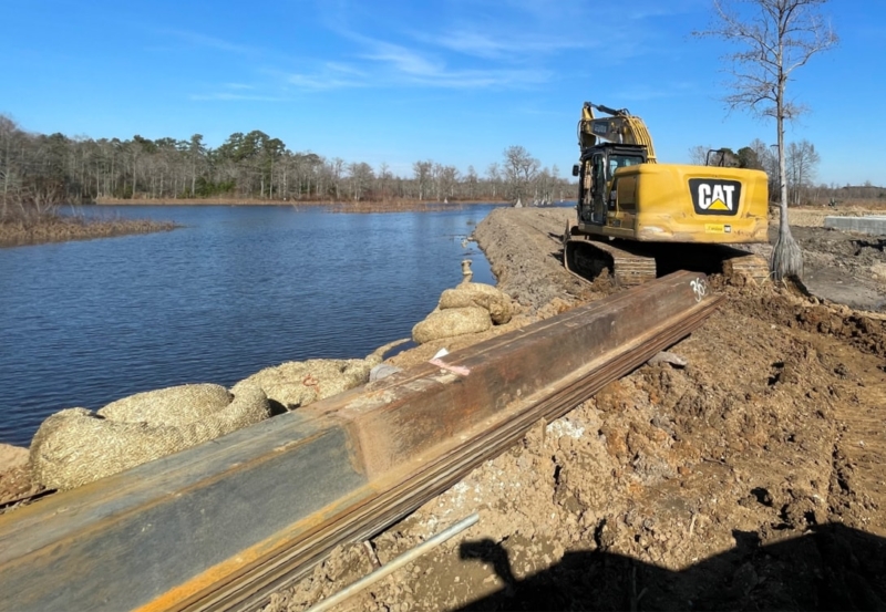 Excavator sitting along the shore of a pond