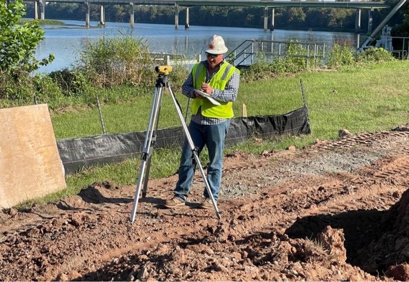 A field surveyor next to a construction site.