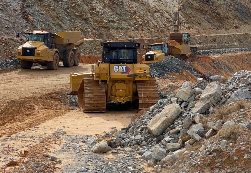 A group of bulldozers on a quarry road.