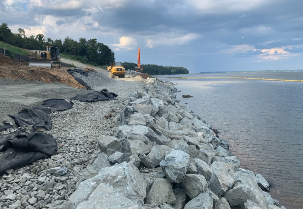 The construction of a retaining wall on the shore of a body of water.